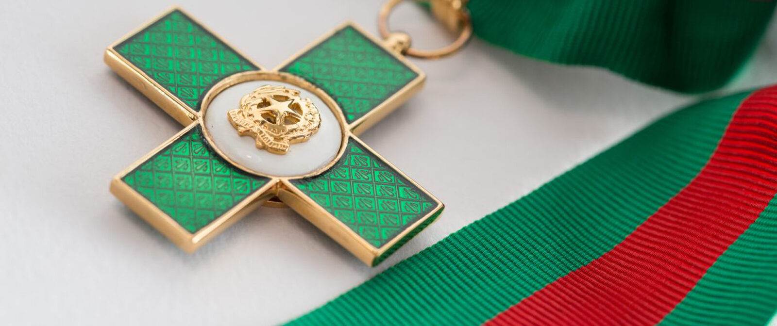 La medaglia per l'onorificenza di Cavaliere del Lavoro. Una croce verde con al centro lo stemma della Repubblica Italiana